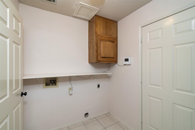 laundry room with washer hookup, light tile patterned floors, a textured ceiling, cabinets, and electric dryer hookup