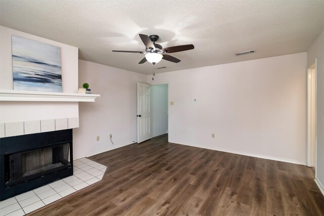 unfurnished living room with a textured ceiling, a fireplace, hardwood / wood-style floors, and ceiling fan