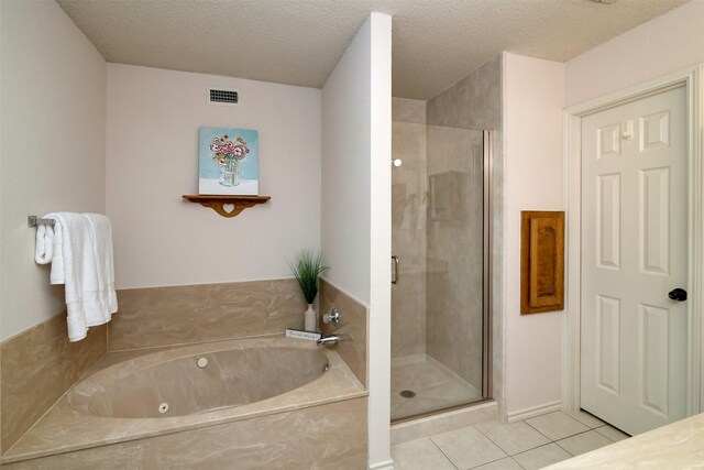 bathroom with a textured ceiling, tile patterned flooring, and separate shower and tub