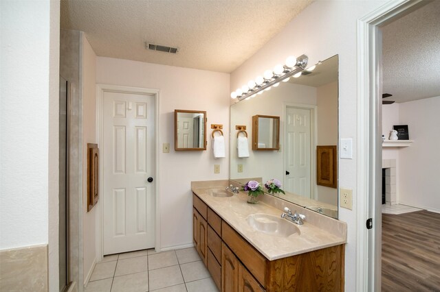 bathroom with a textured ceiling, vanity, and hardwood / wood-style flooring