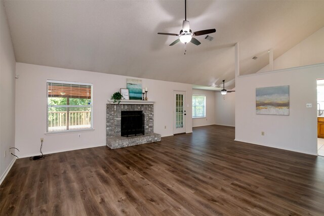 unfurnished living room with lofted ceiling, a fireplace, dark wood-type flooring, and ceiling fan