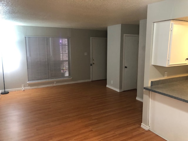 unfurnished living room with a textured ceiling and hardwood / wood-style floors