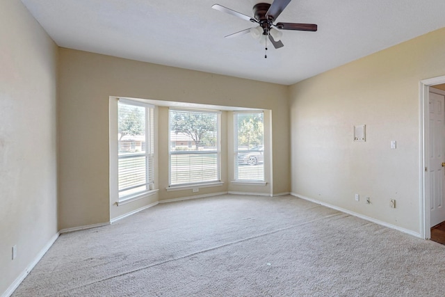 carpeted spare room featuring ceiling fan