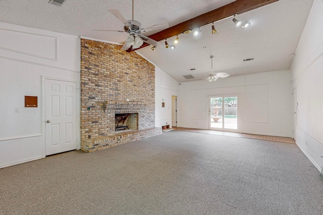 unfurnished living room with ceiling fan, beamed ceiling, carpet floors, and a brick fireplace