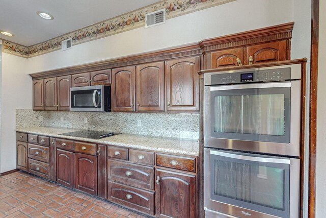 kitchen featuring decorative backsplash, stainless steel appliances, and light stone counters