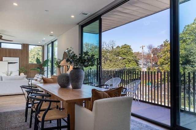 dining room featuring ceiling fan, floor to ceiling windows, and wood-type flooring