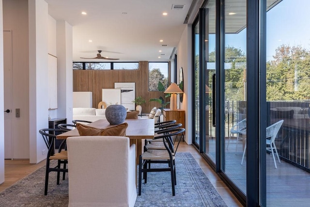 dining area featuring ceiling fan, wood-type flooring, and floor to ceiling windows