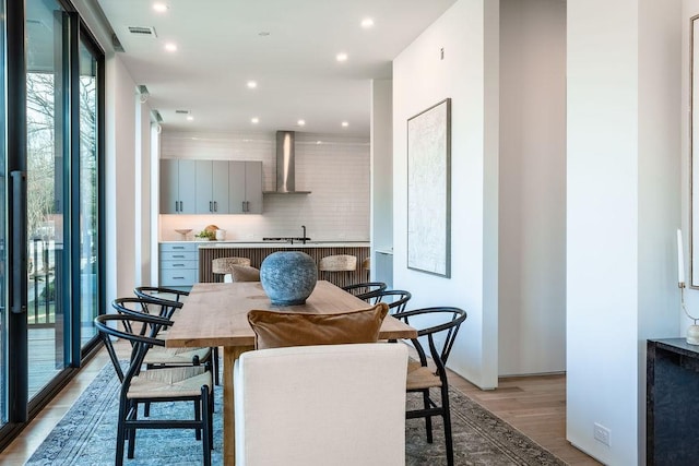 dining space with light hardwood / wood-style flooring and expansive windows