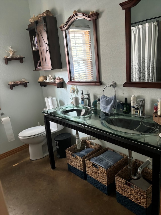 bathroom featuring concrete floors, vanity, and toilet