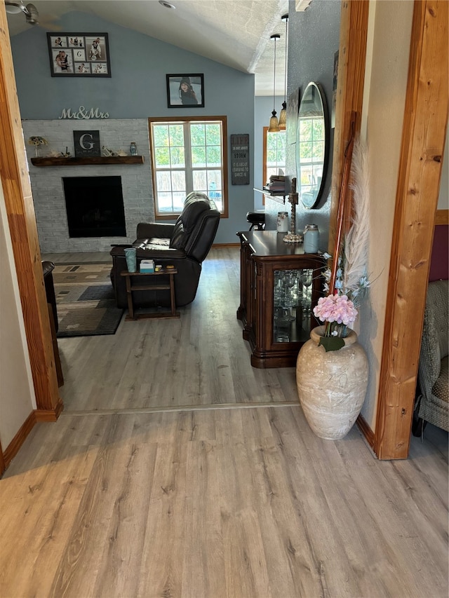 living room featuring a textured ceiling, vaulted ceiling, and hardwood / wood-style flooring