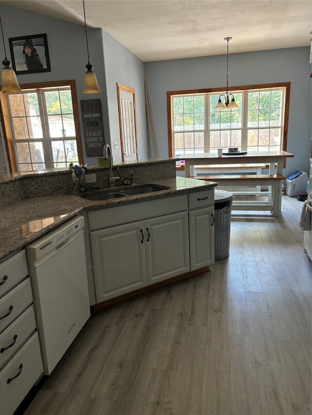 kitchen featuring hanging light fixtures, white cabinets, dishwasher, dark hardwood / wood-style flooring, and sink