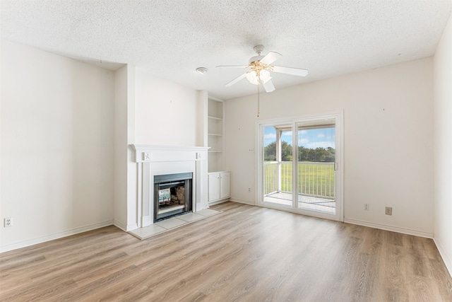 unfurnished living room featuring ceiling fan, a textured ceiling, and light wood-type flooring