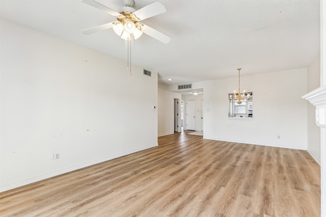 unfurnished living room featuring ceiling fan with notable chandelier and light hardwood / wood-style floors