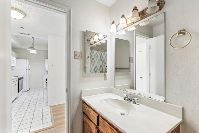 bathroom with vanity, hardwood / wood-style flooring, and a textured ceiling