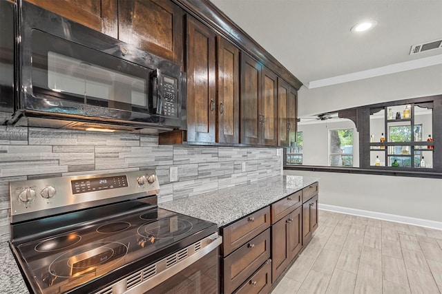 kitchen featuring light stone countertops, backsplash, dark brown cabinets, crown molding, and electric range