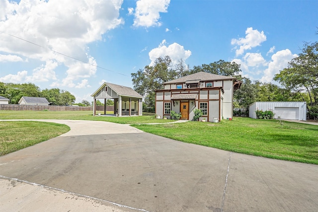 view of front of house with a garage, an outdoor structure, and a front lawn