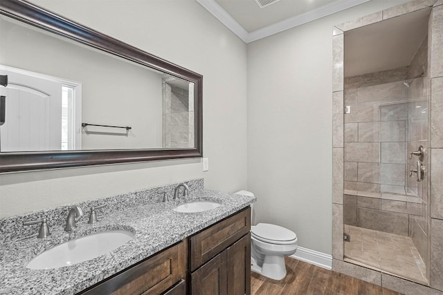 bathroom featuring vanity, toilet, walk in shower, and crown molding