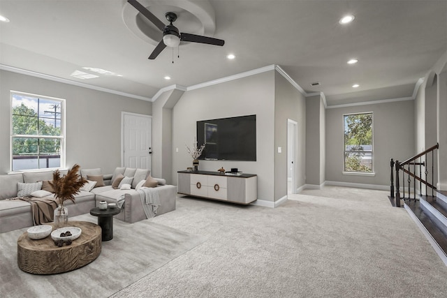 living room featuring ceiling fan, ornamental molding, and light carpet