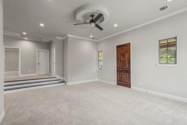 carpeted spare room with ceiling fan and crown molding