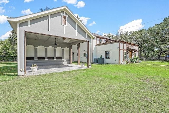 rear view of house featuring central AC, ceiling fan, a yard, and a patio