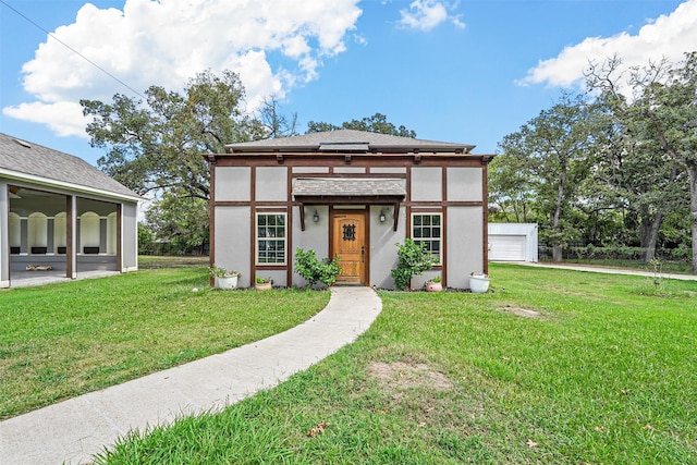 view of front of home with a front lawn and an outdoor structure