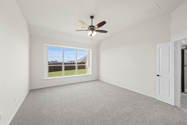 spare room featuring ceiling fan, vaulted ceiling, and light carpet