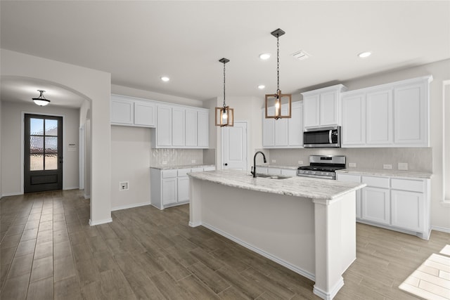 kitchen with a kitchen island with sink, white cabinetry, sink, and stainless steel appliances