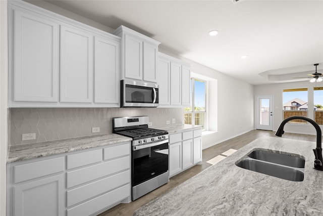 7701 Oakmeade St, Joshua, TX 76058 - kitchen with appliances with stainless steel finishes, a sink, backsplash, white cabinets, and recessed lighting