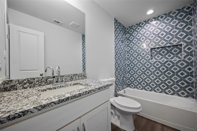 full bathroom with wood-type flooring, bathing tub / shower combination, vanity, and toilet