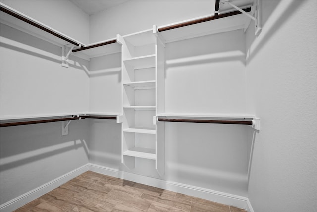 walk in closet with light wood-type flooring