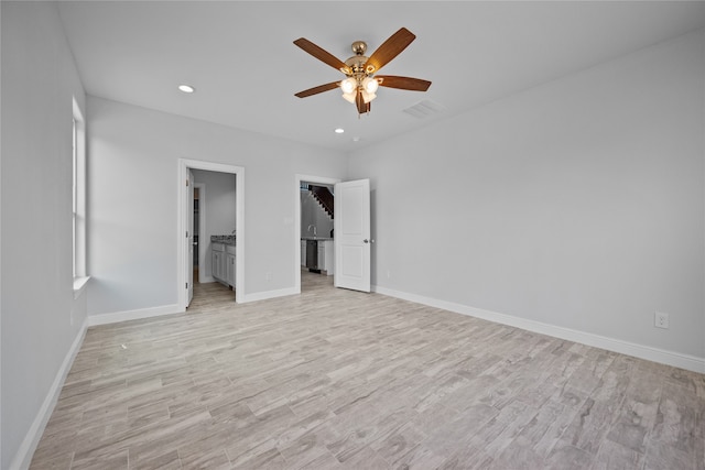 unfurnished bedroom featuring light hardwood / wood-style floors, ceiling fan, and ensuite bath