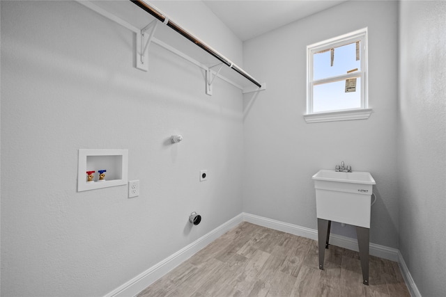 clothes washing area with light wood-type flooring, hookup for an electric dryer, and washer hookup