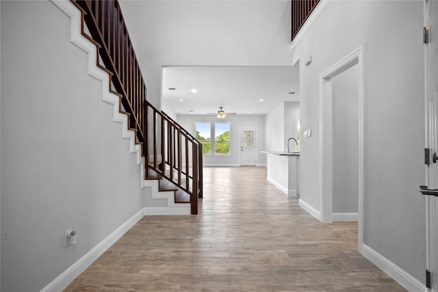 foyer featuring ceiling fan, sink, and light hardwood / wood-style floors