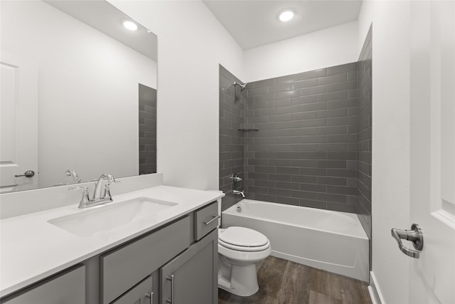 full bathroom with hardwood / wood-style floors, vanity, toilet, and tiled shower / bath