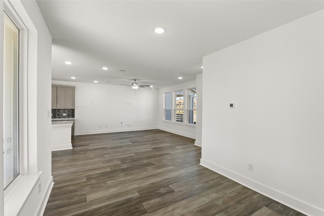 unfurnished living room featuring ceiling fan and dark hardwood / wood-style flooring