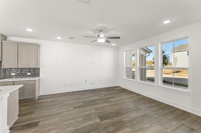 unfurnished dining area with ceiling fan and dark hardwood / wood-style floors