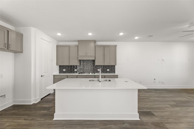 kitchen featuring dark wood-type flooring, a kitchen island with sink, gray cabinetry, and sink