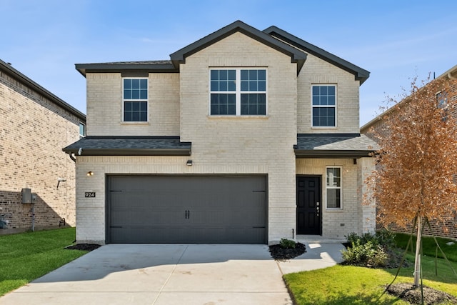 view of front of house with a shingled roof, concrete driveway, an attached garage, a front lawn, and brick siding