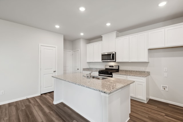 kitchen with a kitchen island with sink, recessed lighting, a sink, appliances with stainless steel finishes, and dark wood-style floors