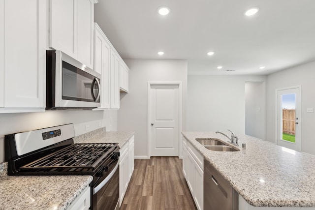 kitchen with white cabinetry, sink, stone countertops, and tasteful backsplash