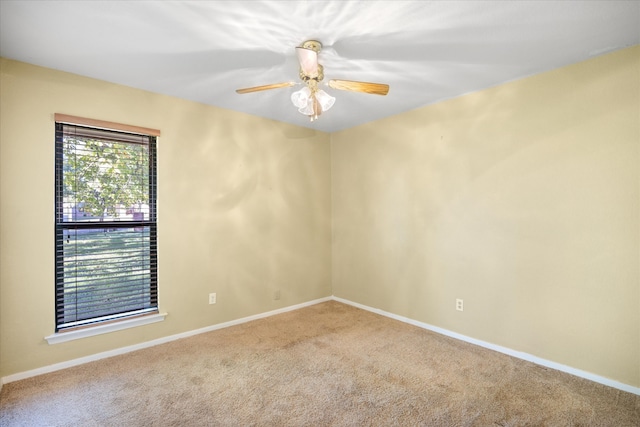 carpeted spare room featuring ceiling fan