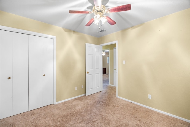 unfurnished bedroom featuring light carpet, a closet, and ceiling fan