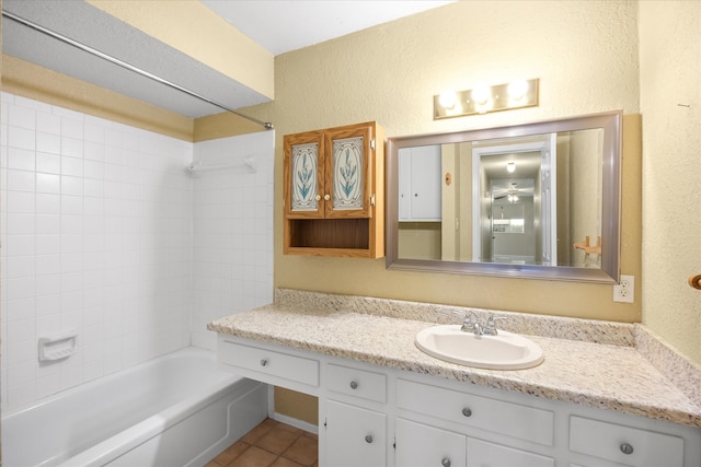 bathroom with vanity, tile patterned flooring, and tiled shower / bath