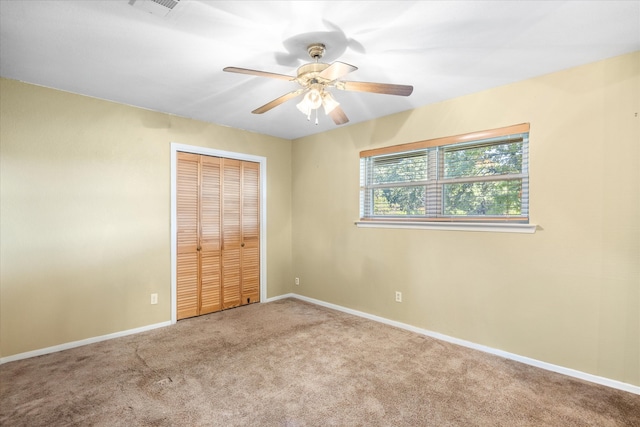 unfurnished bedroom featuring a closet, carpet, and ceiling fan