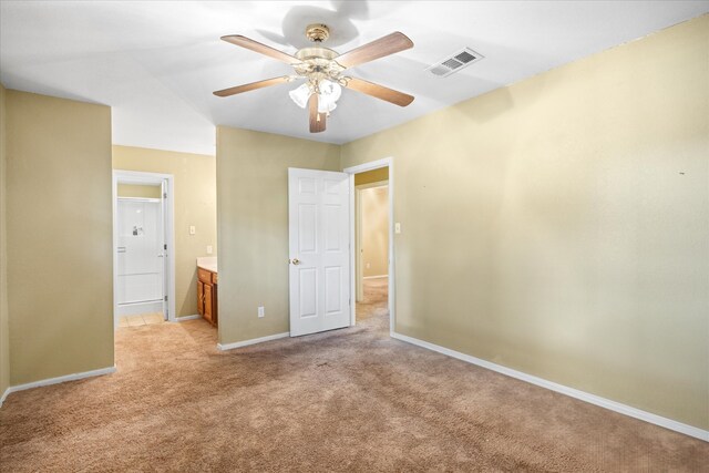 unfurnished bedroom with light carpet, ensuite bath, and ceiling fan