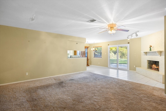 unfurnished living room with light carpet, a fireplace, ceiling fan, and rail lighting