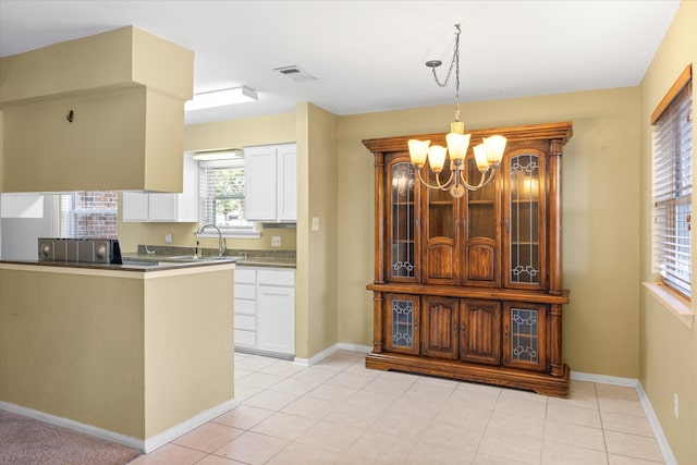 kitchen with a notable chandelier, decorative light fixtures, sink, and white cabinetry