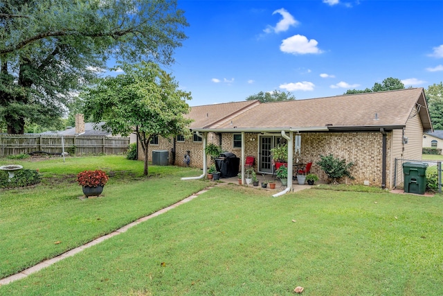 back of house featuring a lawn, a patio area, and central AC