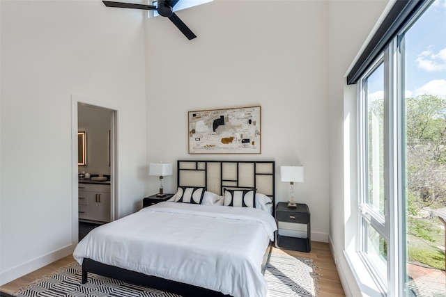 bedroom featuring wood-type flooring, connected bathroom, and multiple windows