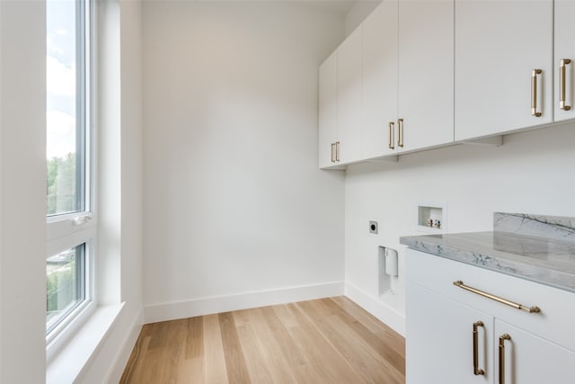 clothes washing area with washer hookup, light hardwood / wood-style flooring, hookup for an electric dryer, and a healthy amount of sunlight